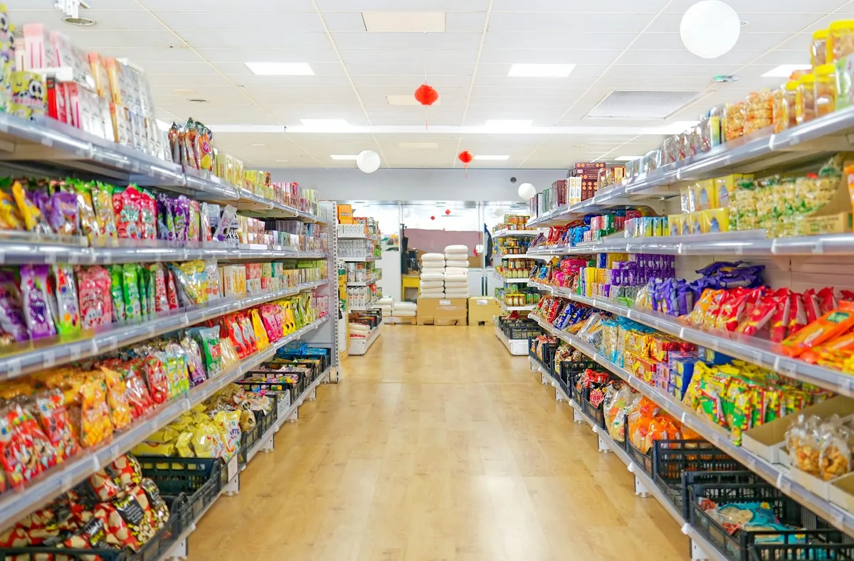 Longue allée de rayons de produits du monde chez H.ASIE
